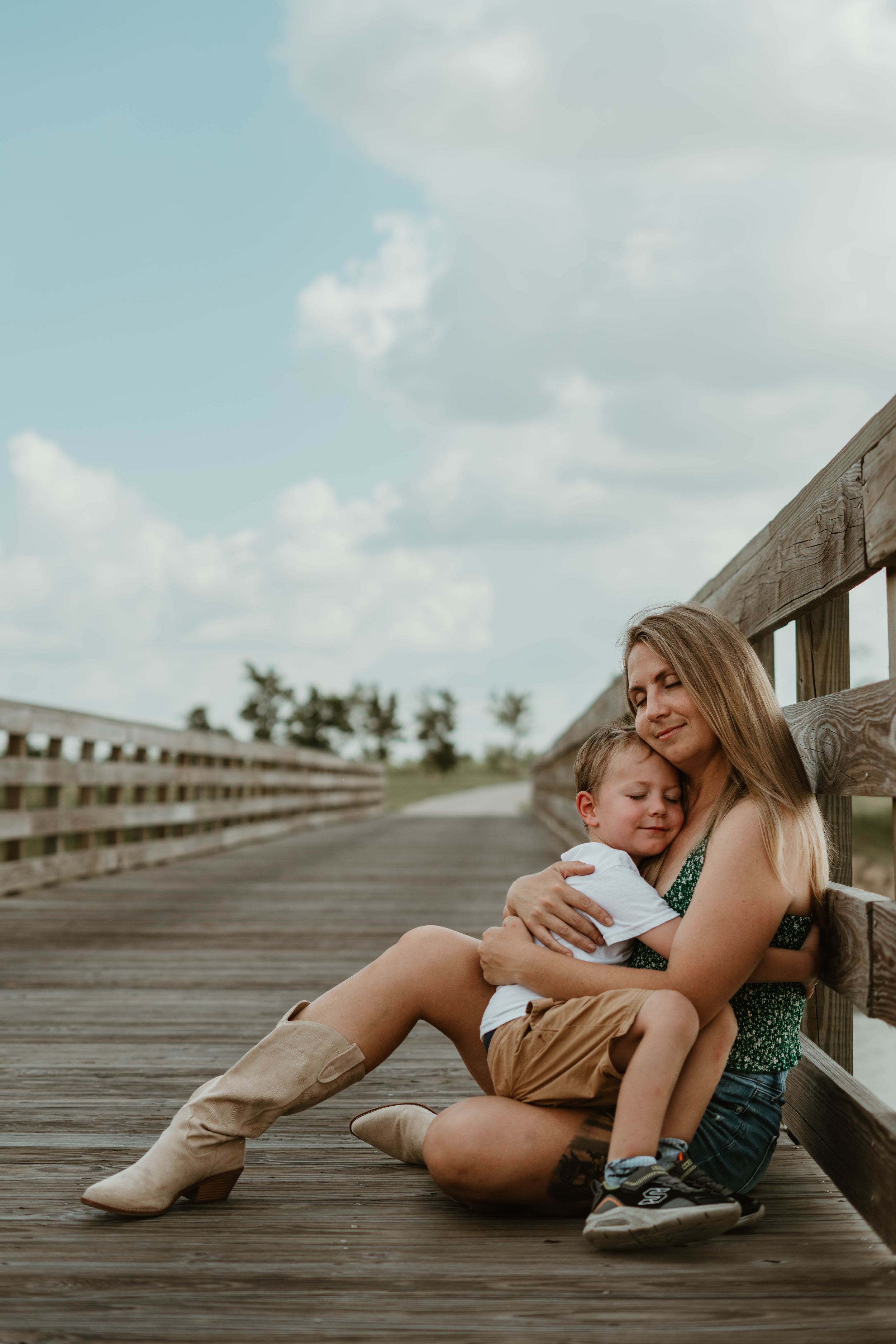 Intimate portrait on wooden boardwalk with boots and casual attire.