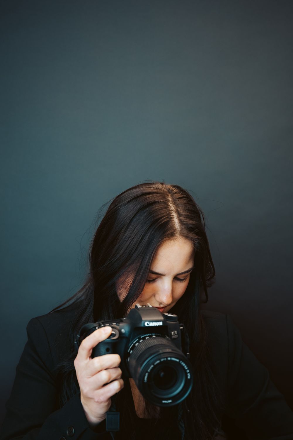 Fun studio business branding photoshoot of a photographer. girl posing in a dark backdrop for her headshot . Fort Collins colorado photos