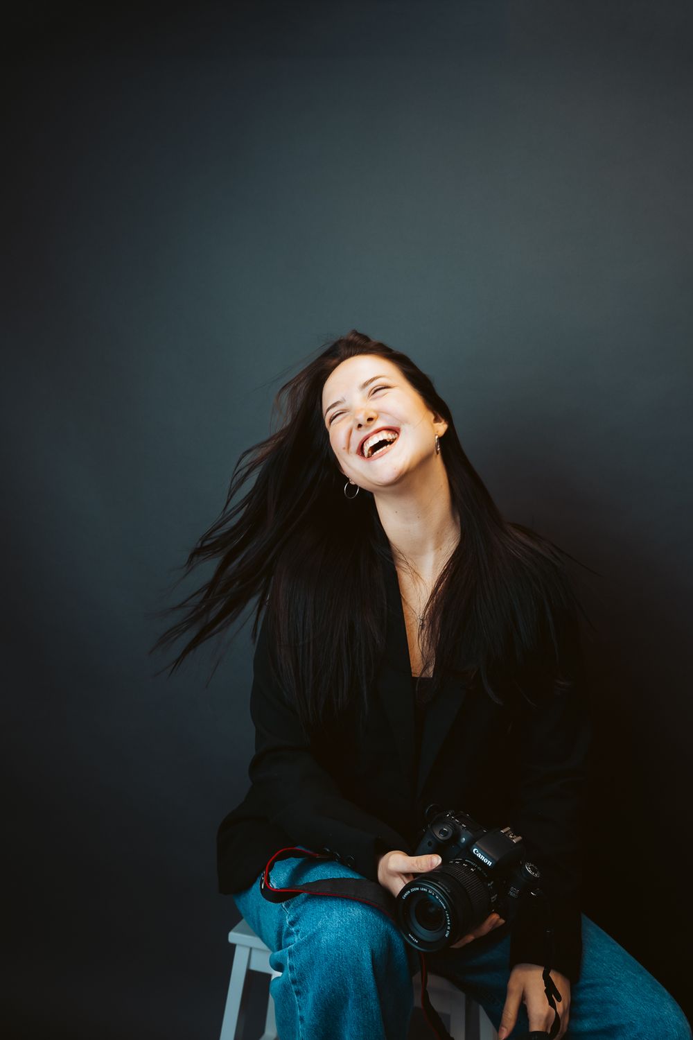Fun studio business branding photoshoot of a photographer. girl posing in a dark backdrop for her headshot . Fort Collins colorado photos