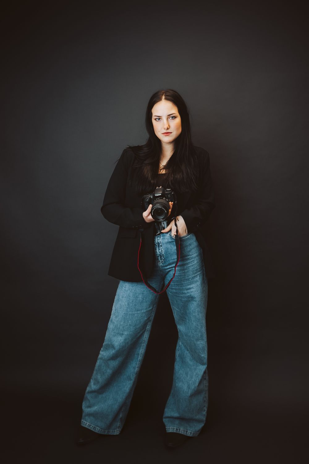 Fun studio business branding photoshoot of a photographer. girl posing in a dark backdrop for her headshot . Fort Collins colorado photos