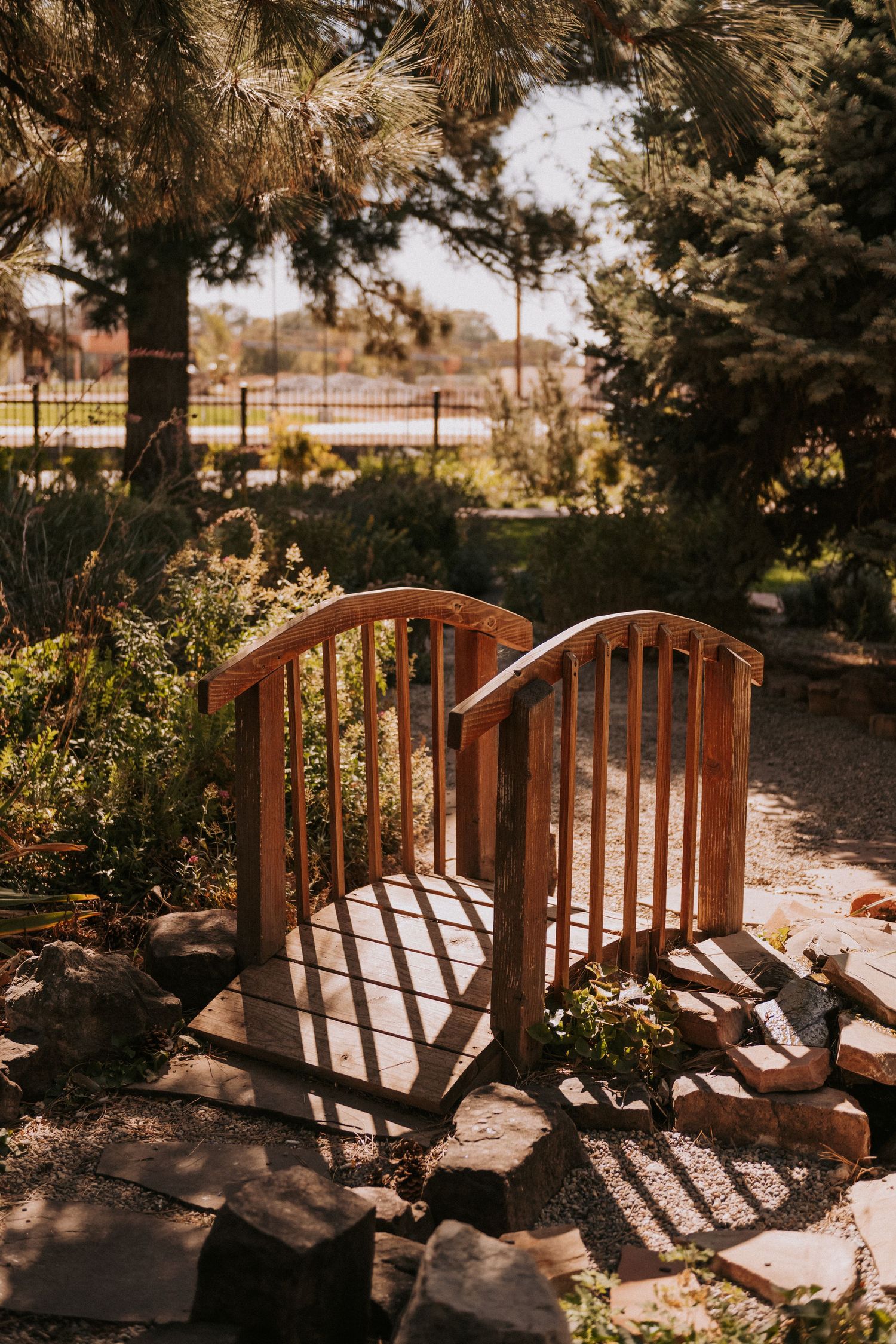 Wooden footbridge casts shadows on a sunny day. Small weddings in New Mexico. Intimate wedding venues. Albuquerque Garden Center Weddings.