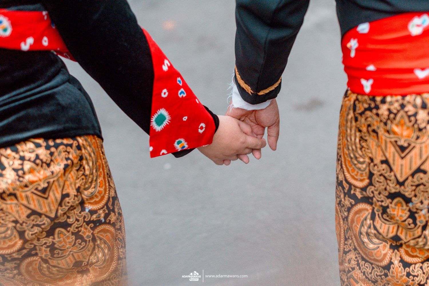 Close-up of matching tattoo sleeves and clasped hands with one person wearing red patterned socks.