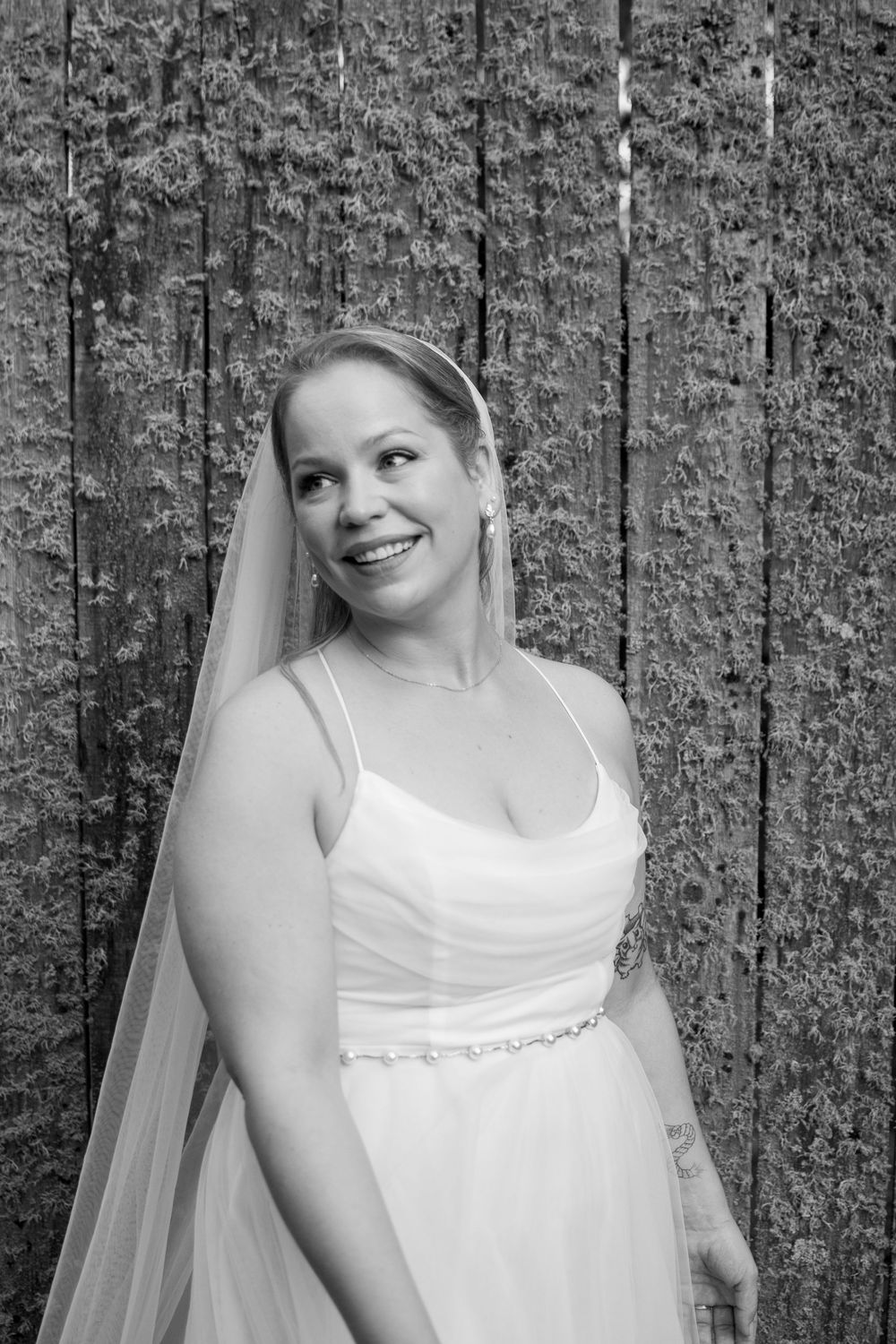 A series of black and white bridal portraits showing someone in a white wedding dress against a textured wall background.