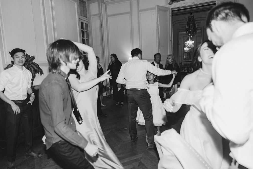 People enjoying lively dance moves at a wedding reception in an elegant indoor venue.