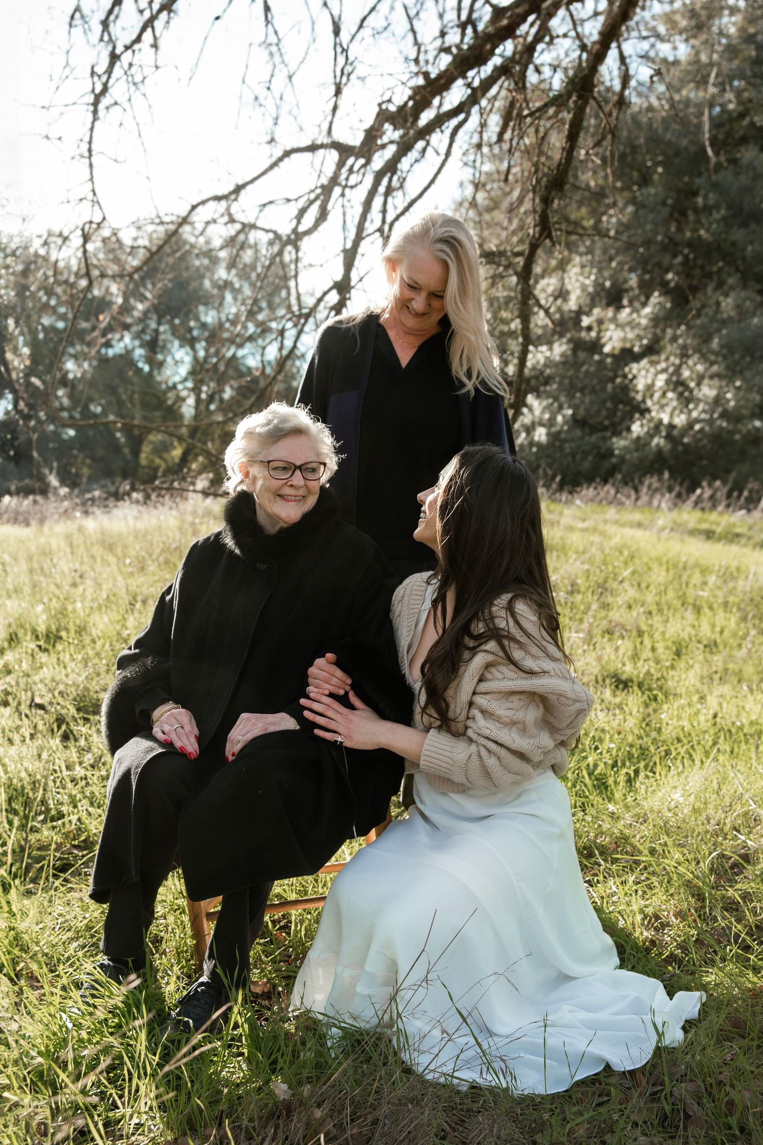 Touching family portrait set in sunlit meadow with natural styling.
