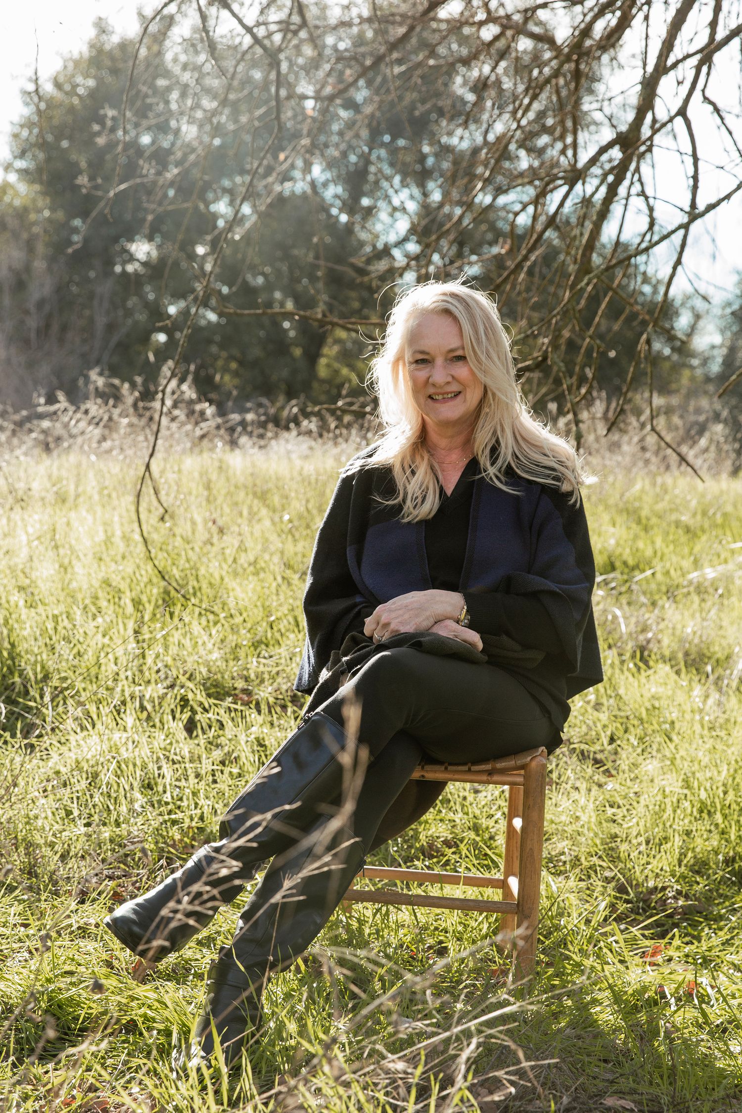 Relaxed outdoor portraits on a wooden bench surrounded by tall grass and natural sunlight.