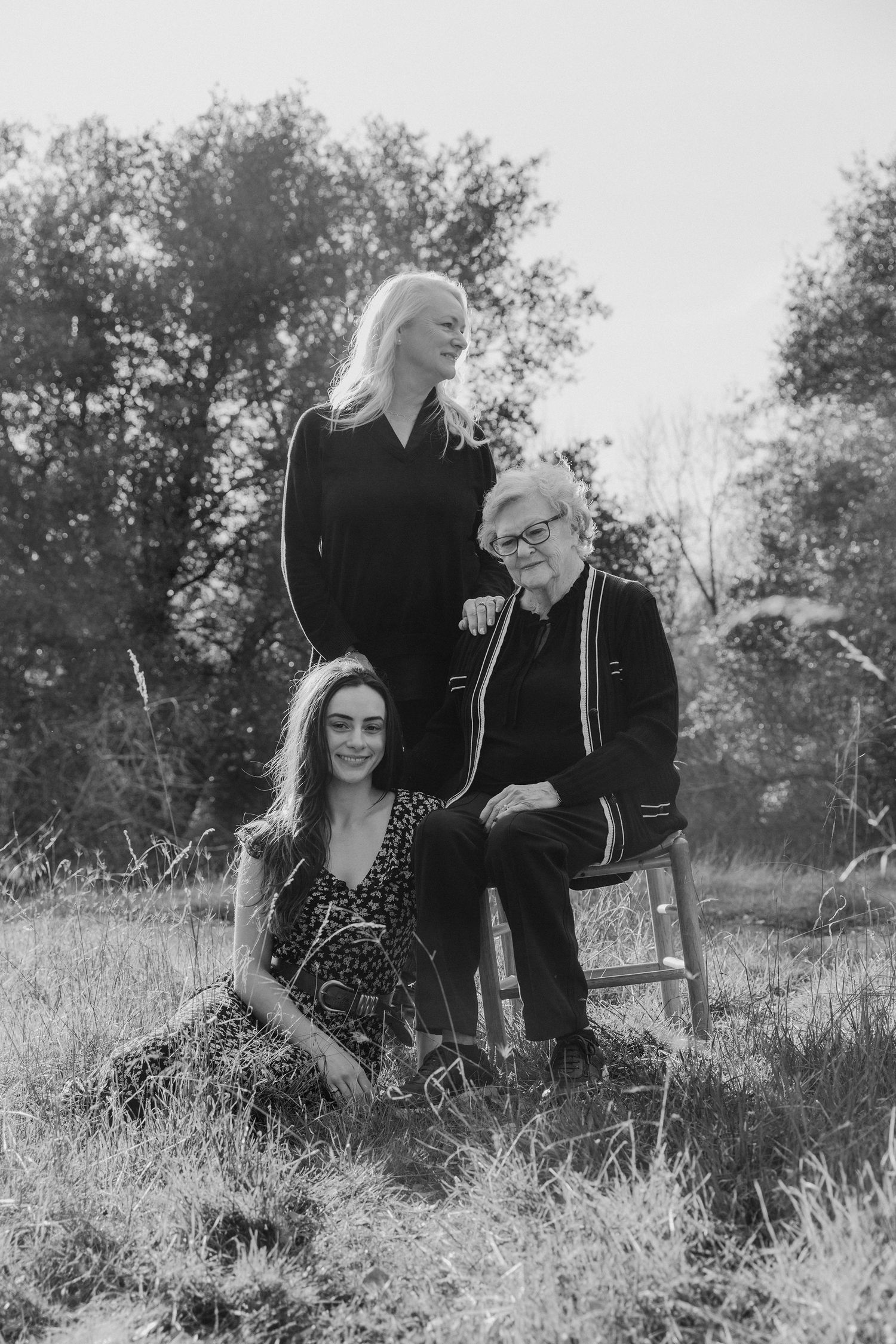 Natural black and white portraits in a grassy field with soft lighting.