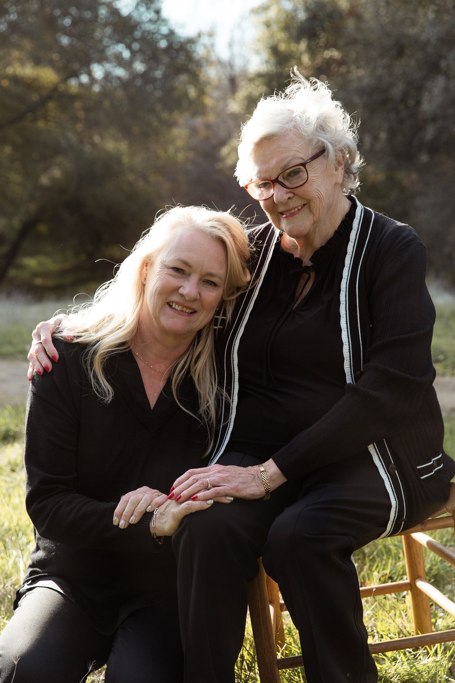 Intimate outdoor portraits on a wooden bench with warm natural lighting.
