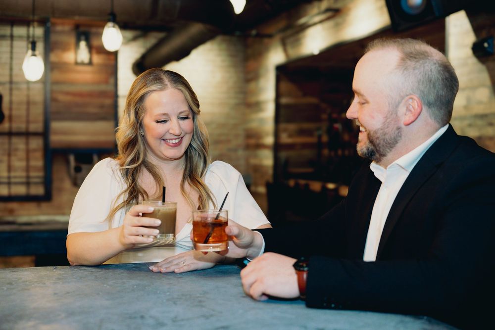 Two people enjoying coffee and conversation while sitting at a bar counter in a cafe with rustic wood decor.