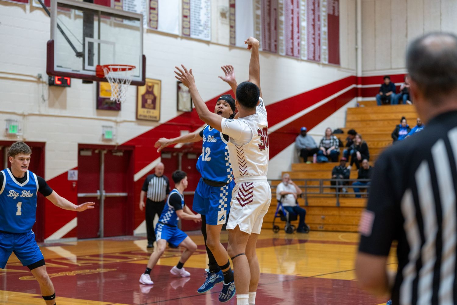 Players from opposing teams battle for position during an intense basketball game.