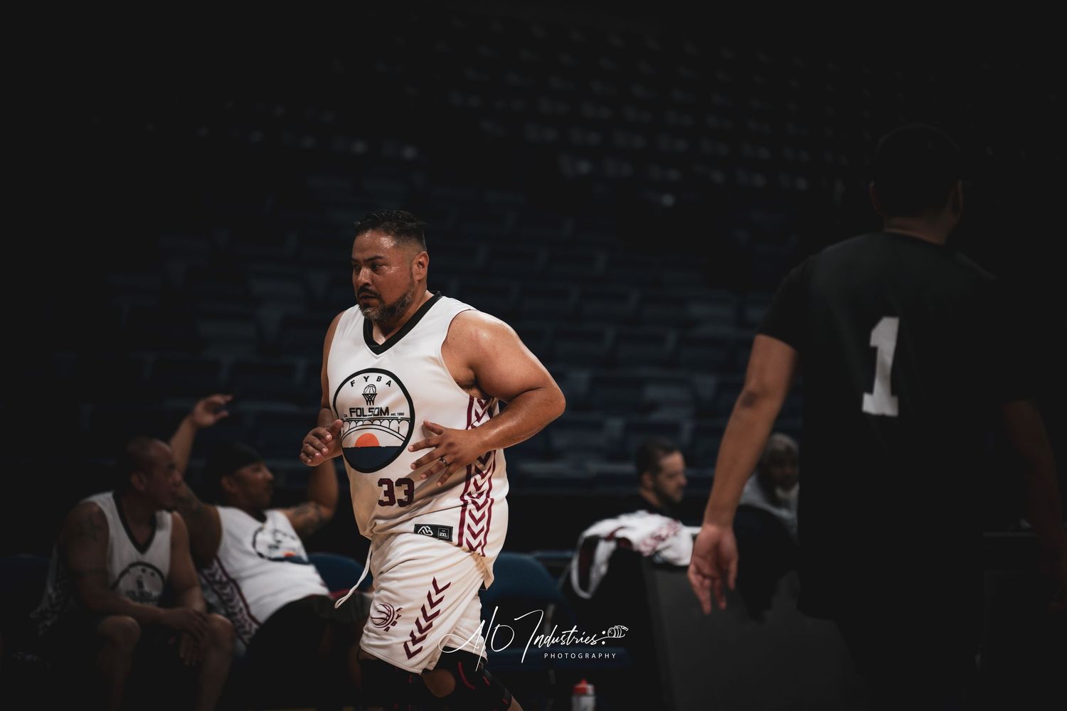 Basketball player wearing number 33 in a white uniform jogs on an indoor court during a game.