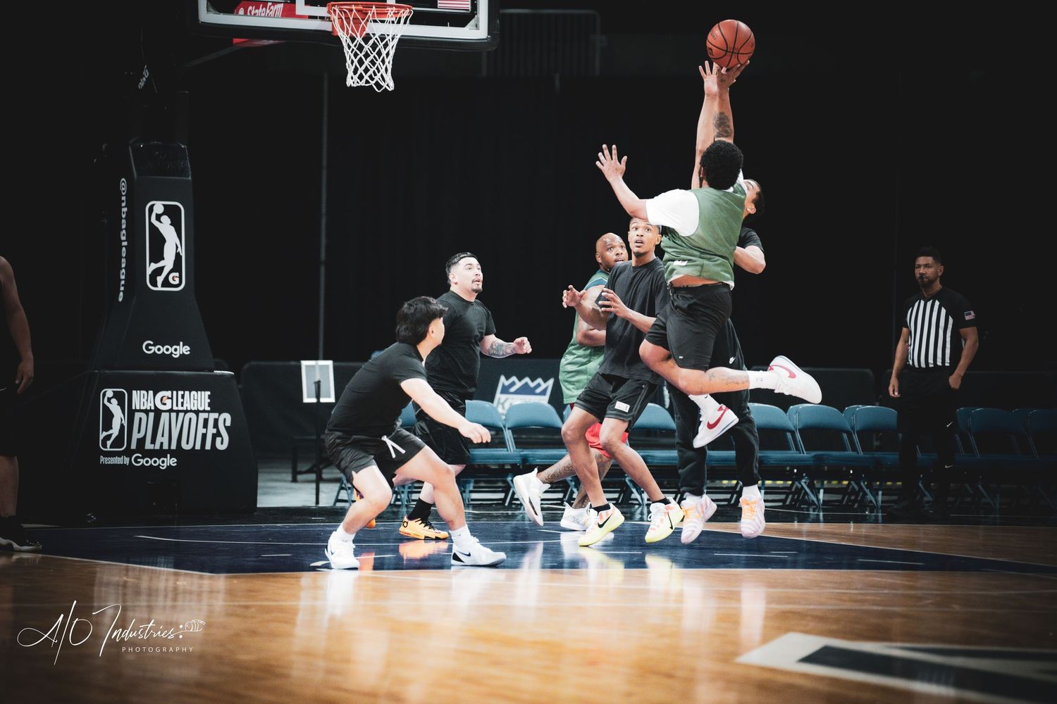 Players compete in an intense NBA G League playoff basketball game with a referee watching nearby.