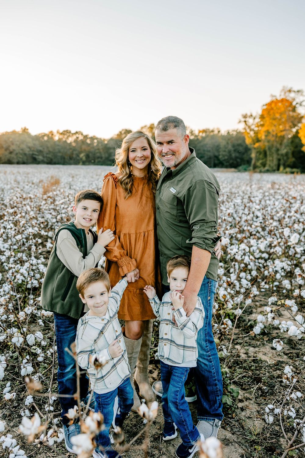 Rustic charm at Cotton Hill Farms in McConnells, SC—parents and kids framed by fluffy cotton bolls at sunset