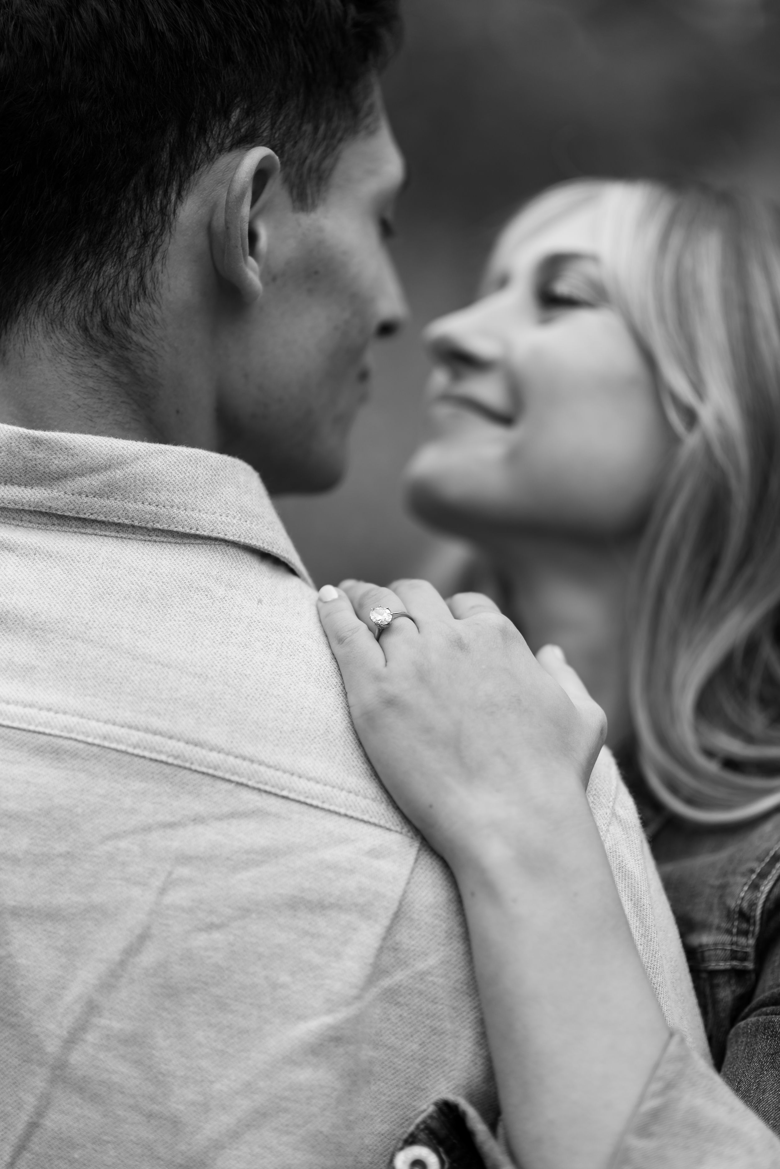 A romantic black and white close-up photograph of a couple sharing an intimate moment.