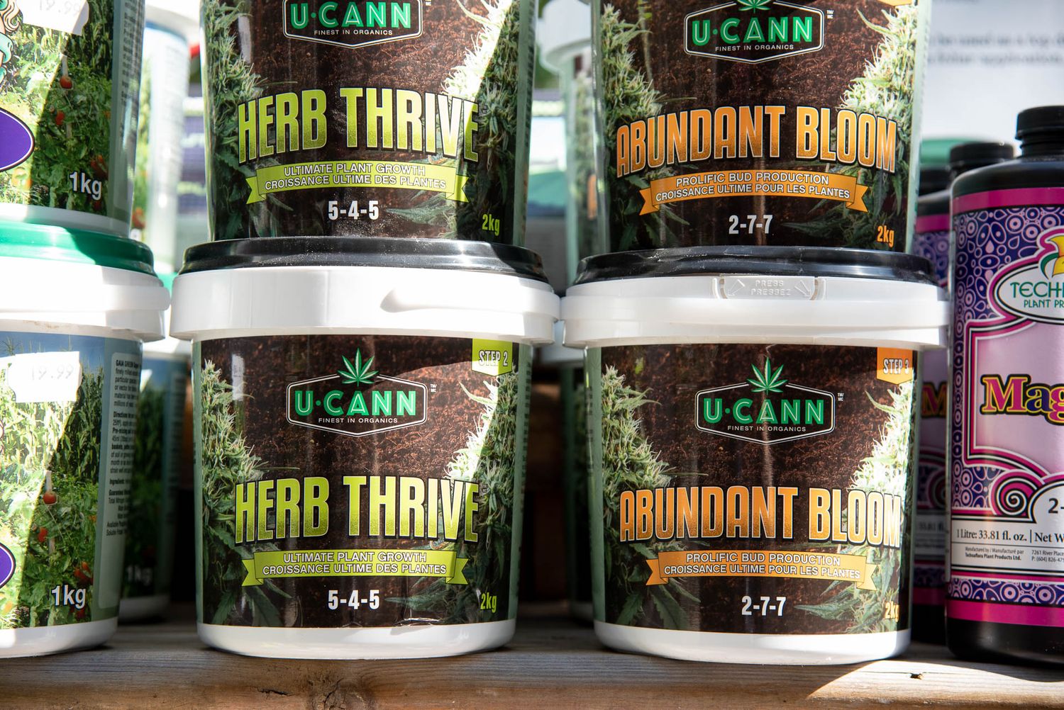 Rows of Ocano brand herbal supplement containers with 'Herb Thrive' and 'Abundant Bloom' labels on store shelves at Bradford Greenhouse