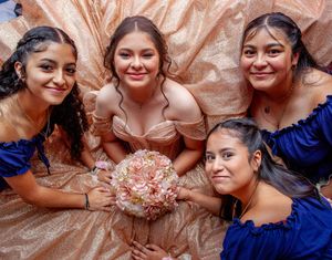 Group photo showing rose gold quinceañera dresses with blue accent details.