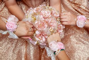 Detailed shot of pink floral arrangements against sparkly rose gold fabric.