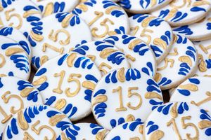 Decorative pattern featuring blue floral designs and golden numbers 15 on a white background.