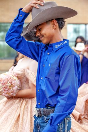 Person in bright blue western shirt and gray cowboy hat striking playful poses.