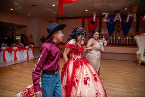Dance floor scene at a quinceañera celebration with traditional formal attire.