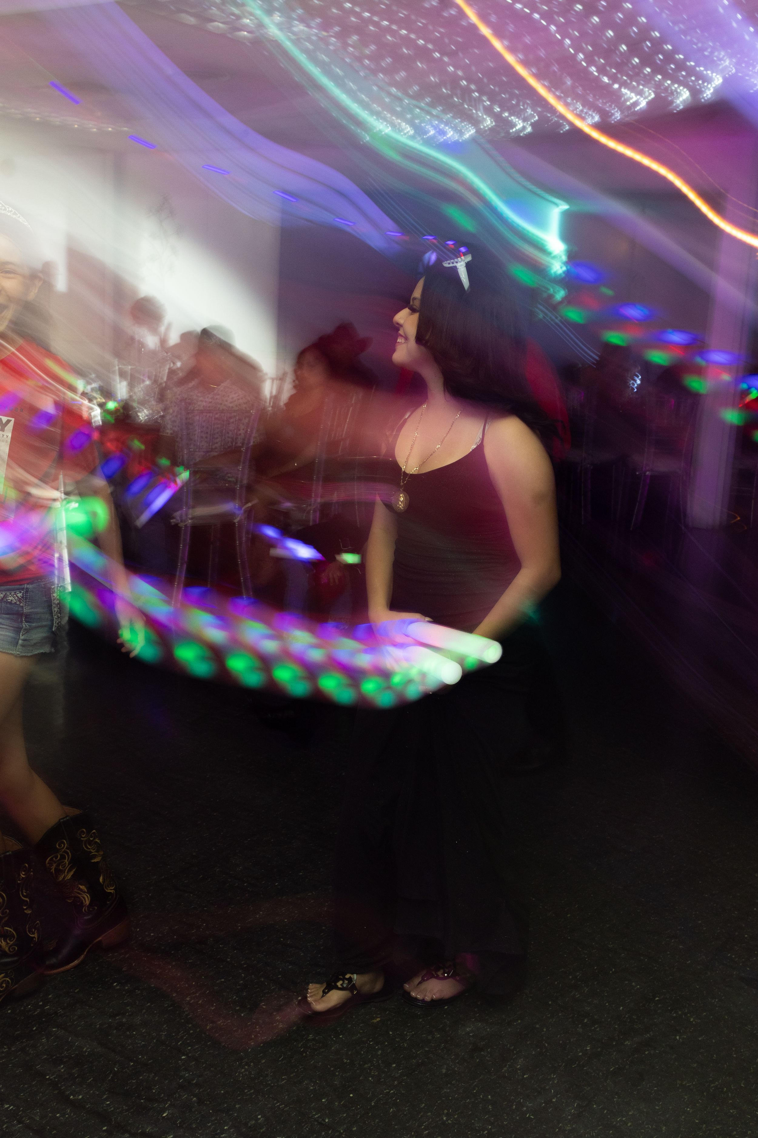 Motion-blurred dance floor photo with colorful disco lights creating streaks of purple and blue.