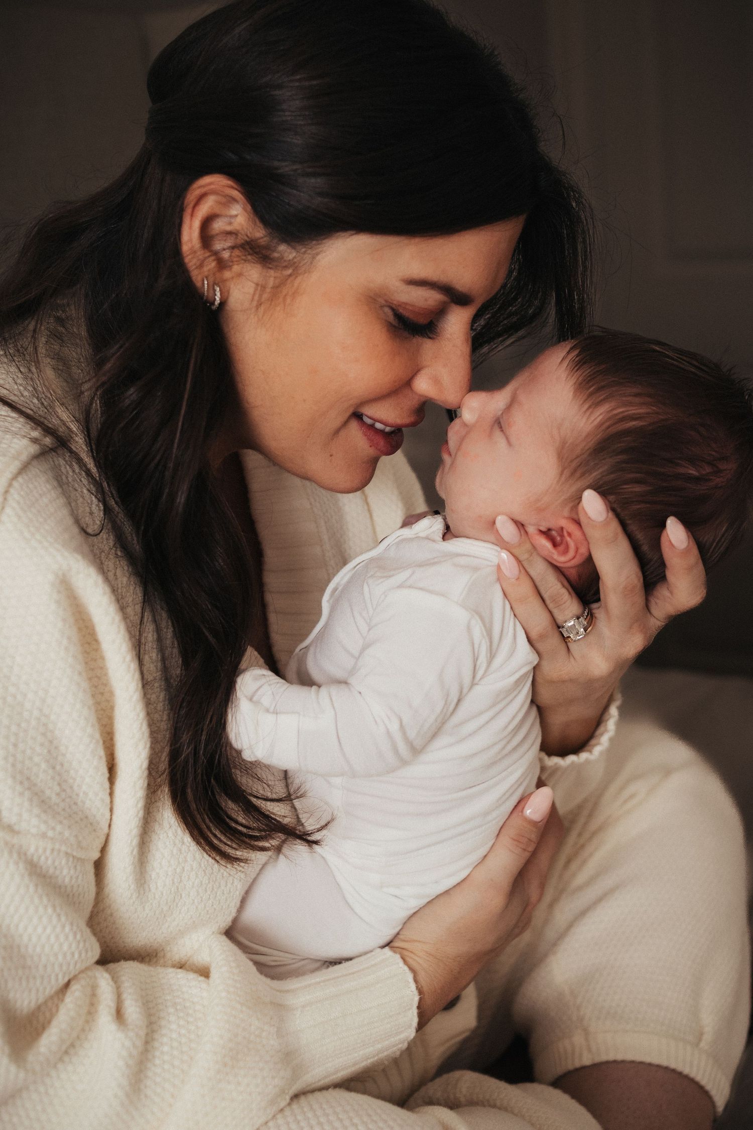 An intimate moment between mother and newborn in soft indoor lighting.