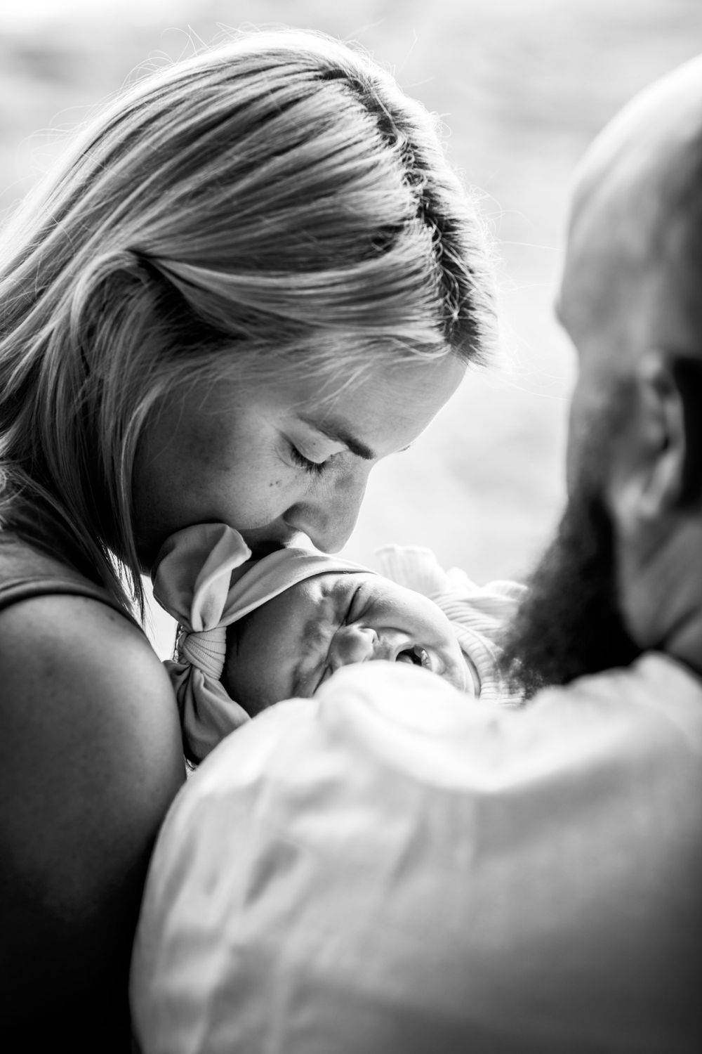 An intimate black and white close-up portrait showing tender family affection.