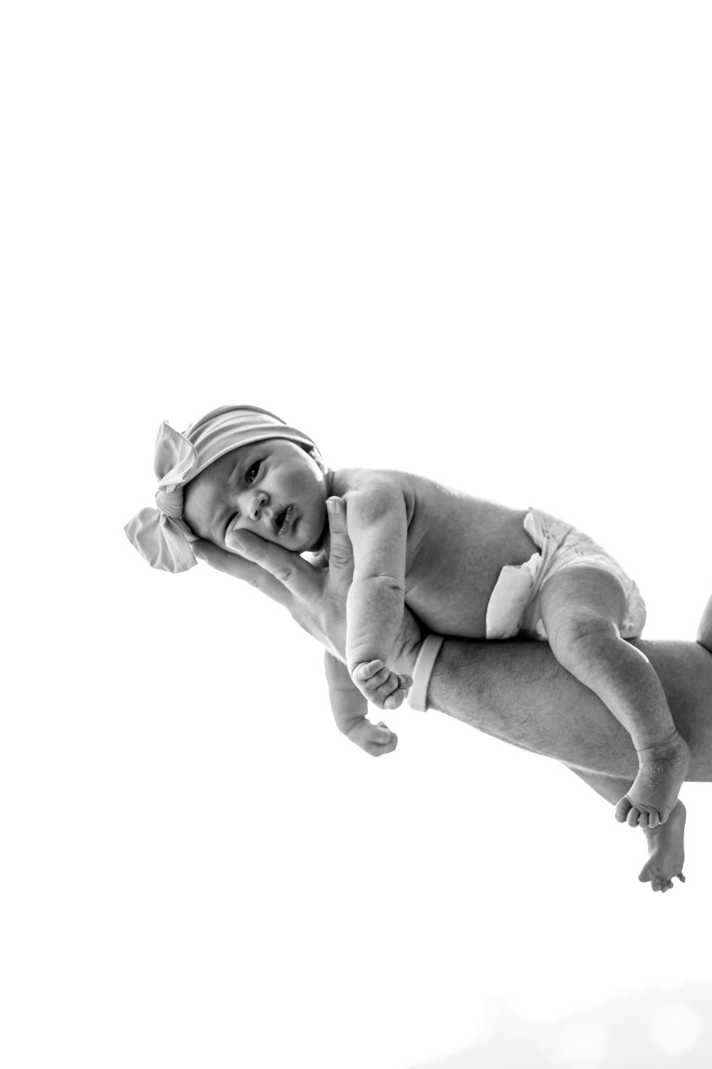 Black and white artistic portrait of a sleeping newborn baby in minimalist style.