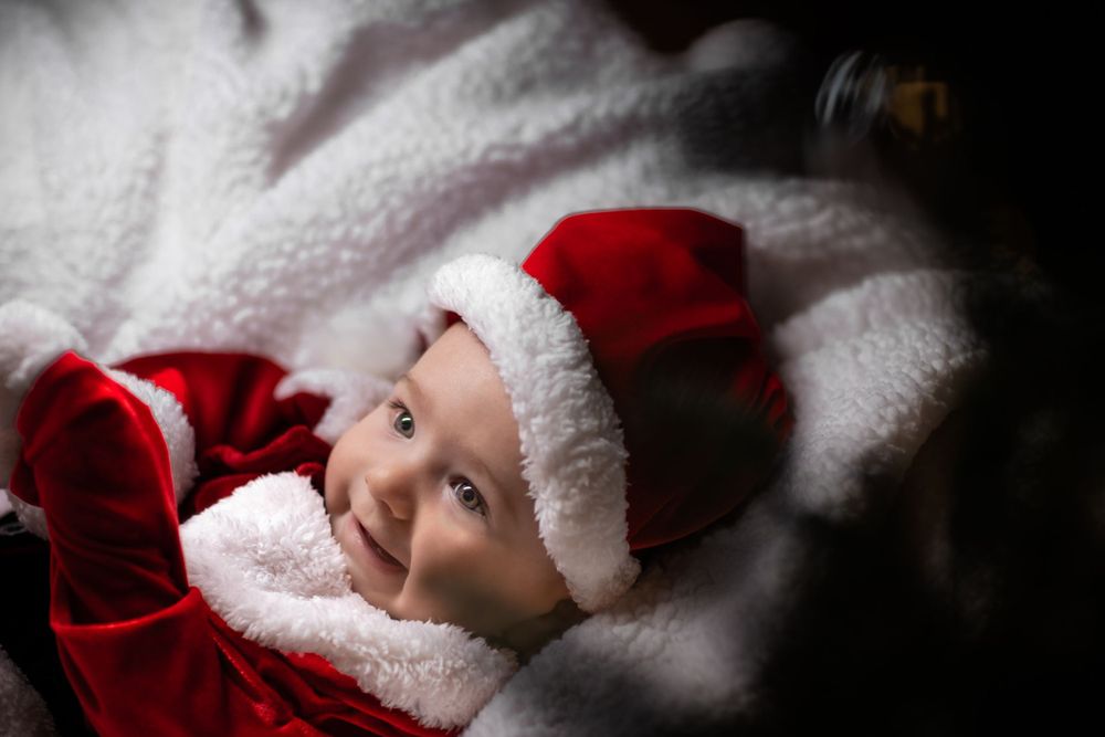 Holiday-themed baby photography setup with red and white decorations.
