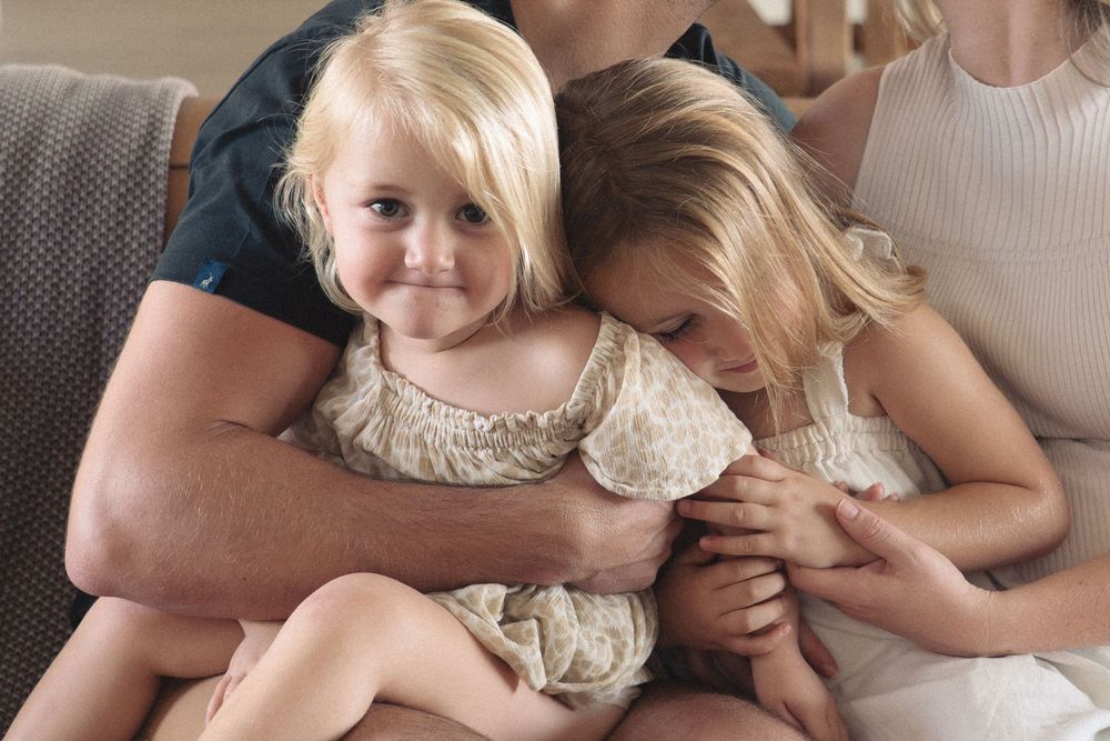 A series of intimate family moments captured in soft, natural lighting showing tender interactions between loved ones.