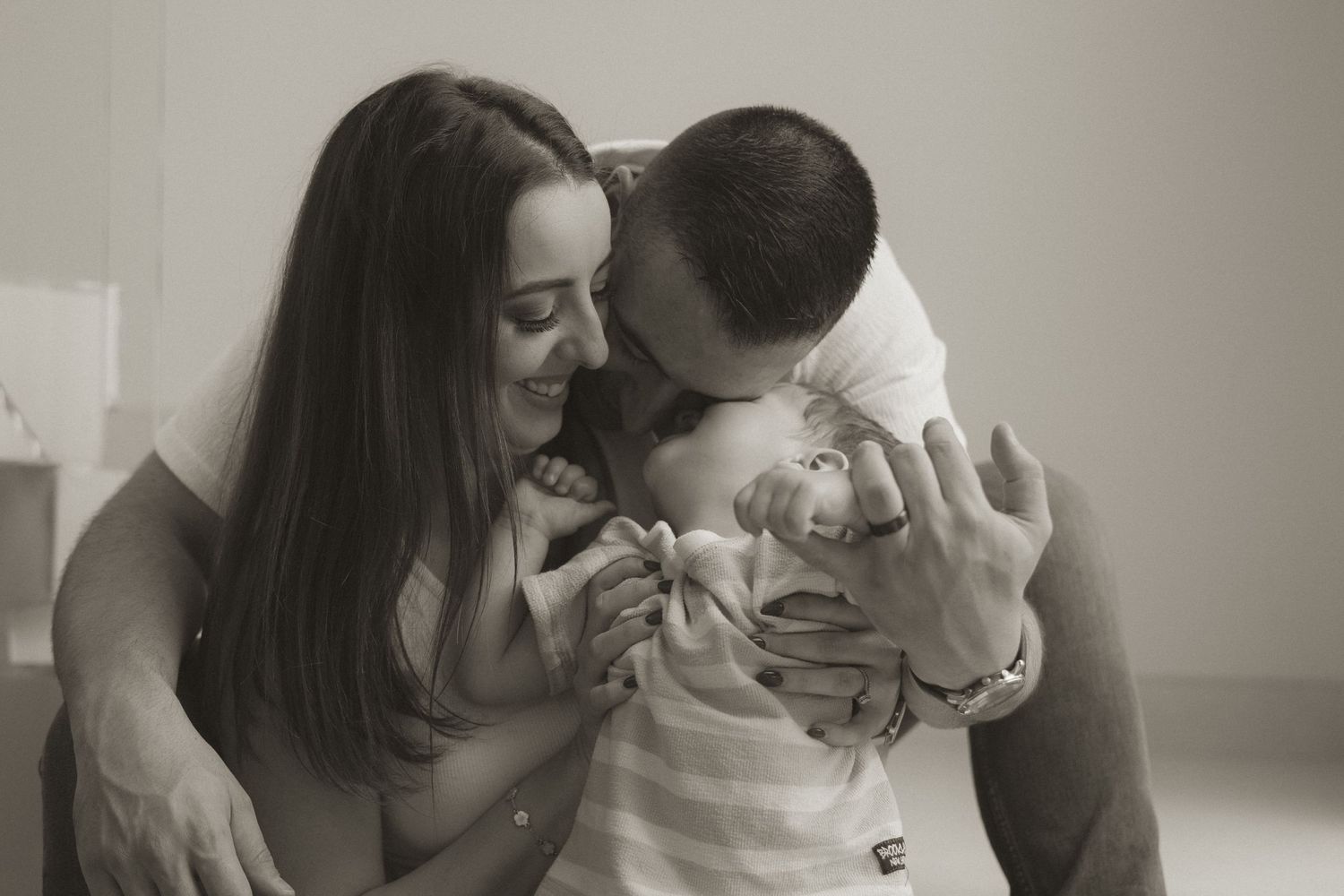A series of intimate black and white photographs showing tender moments between a couple sharing affectionate gestures.