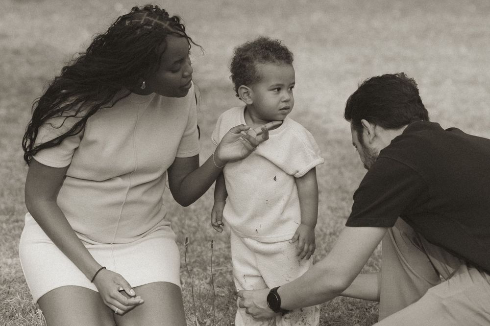 A series of black and white photos showing a baby crawling and learning to walk with support.