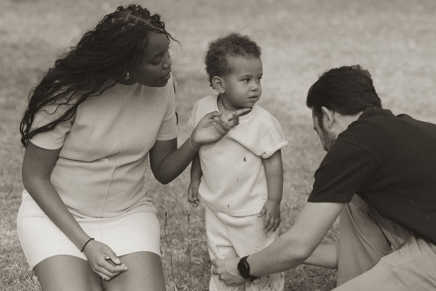A series of black and white photos showing a baby crawling and learning to walk with support.