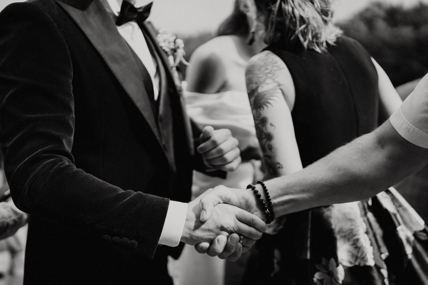 Close-up black and white shot of hands clasping during a wedding ceremony.