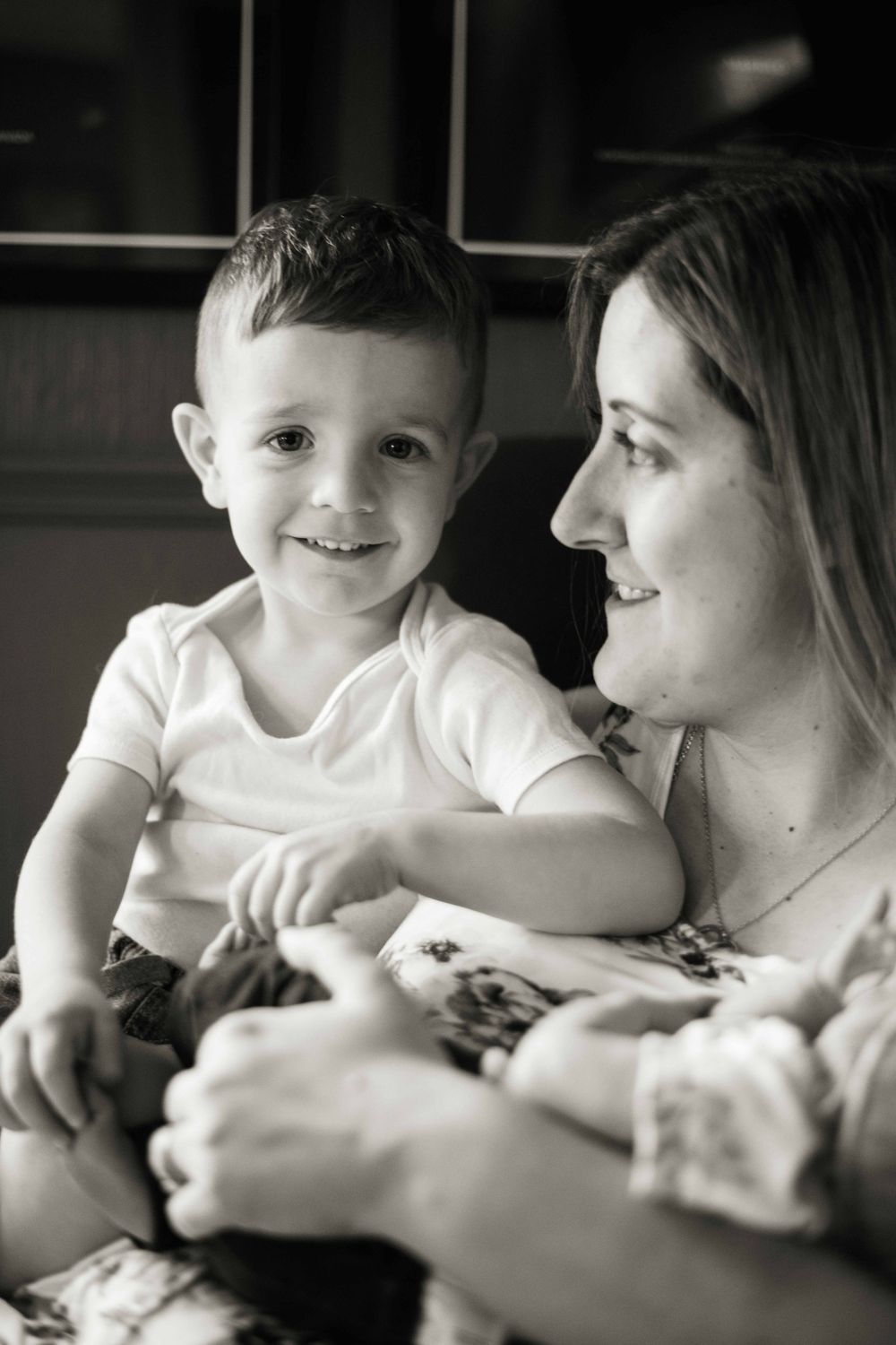 Black and white portrait capturing tender family moment with newborn.