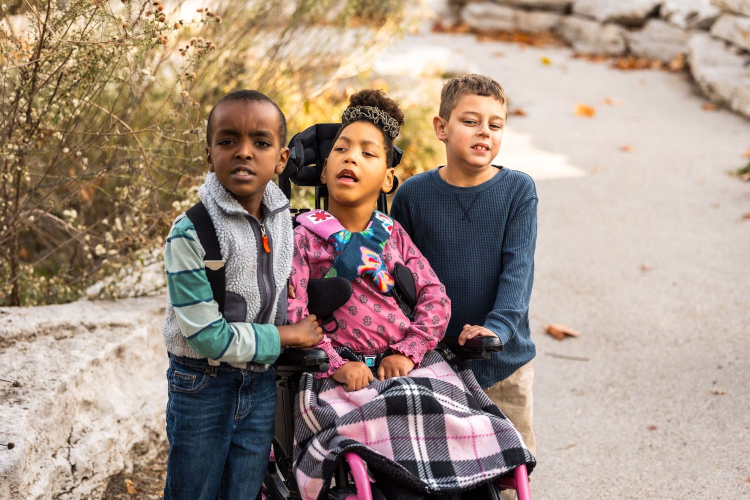 Family members interacting together on outdoor path during autumn photoshoot.
