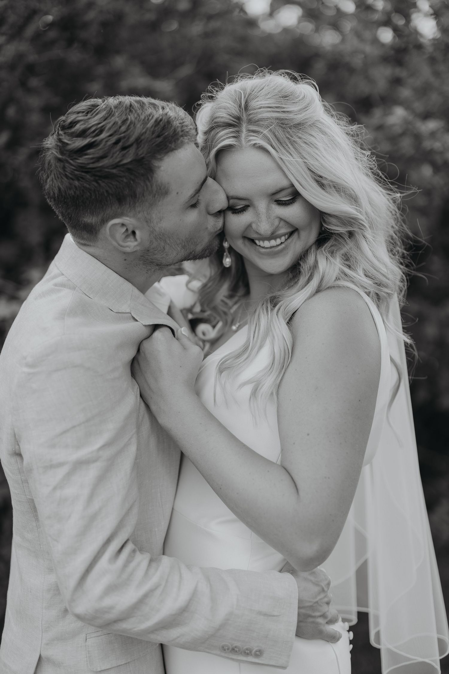 Intimate black and white portrait of newlyweds sharing tender moment.