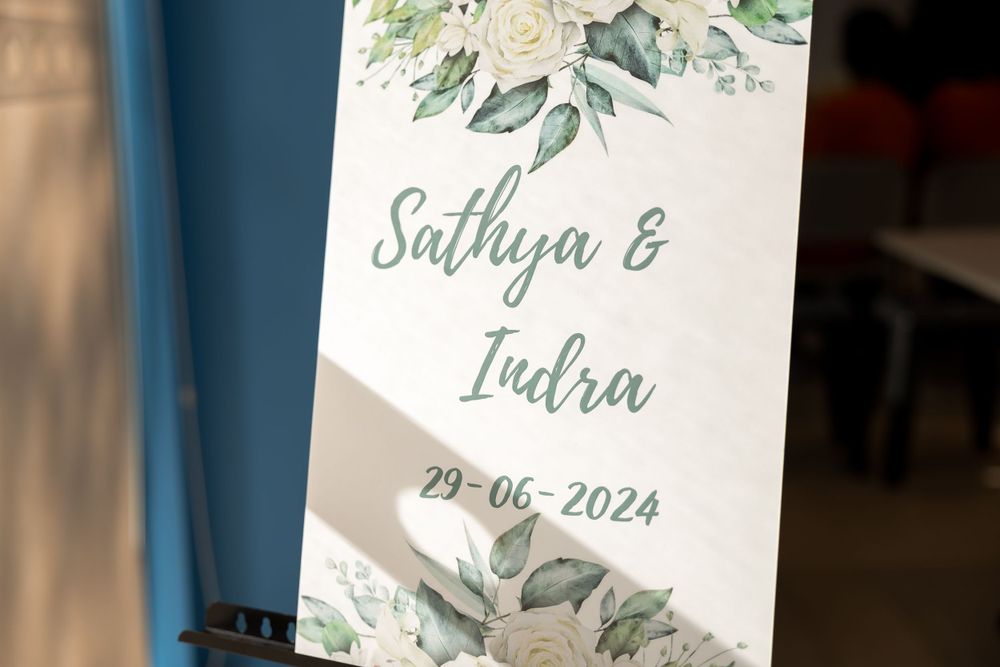 Wedding invitation card with watercolor floral design and sage green text.