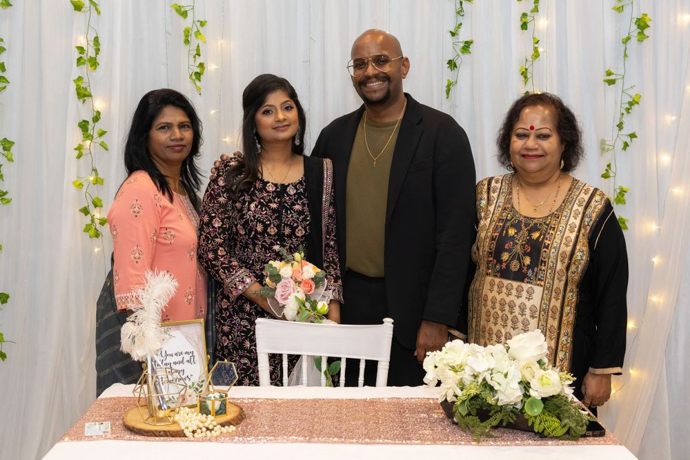 A small group poses together at an elegantly decorated table with white flowers and decor.
