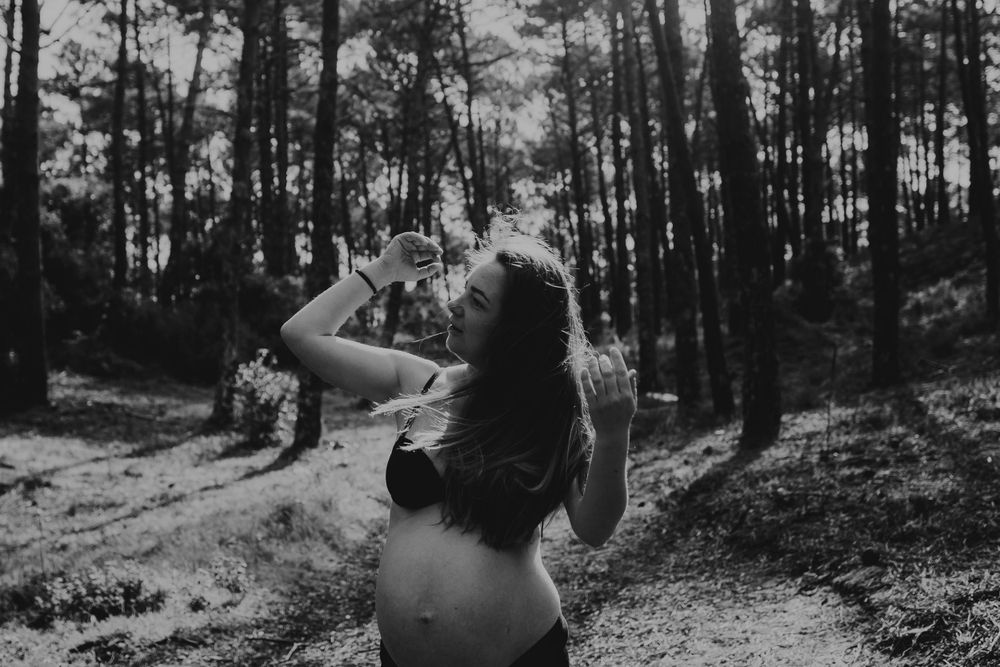 foto preto branco de mulher grávida na natureza em movimento suave durante sessão fotográfica em Alcobaça Portugal