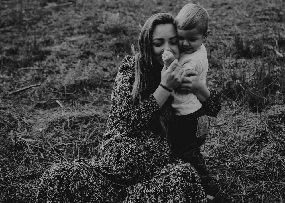 mãe e filho durante momento de afeto, foto preto e branco na natureza em sessão fotográfica de família em Portugal
