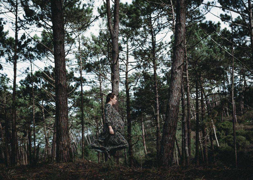 Mulher grávida caminha na floresta em Alcobaça durante sessão fotográfica de gestantes em Alcobaça