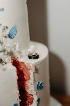 Close-up view of a white wedding cake with red velvet interior and delicate blue butterfly decorations.