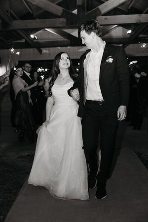 A couple dances together at a wedding reception, with the bride wearing a flowing white ballgown.