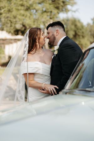 A romantic wedding couple shares intimate kisses next to a car in a series of dreamy outdoor portraits.