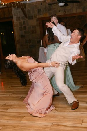 Couple dramatically dipping on the dance floor at a wedding reception celebration.