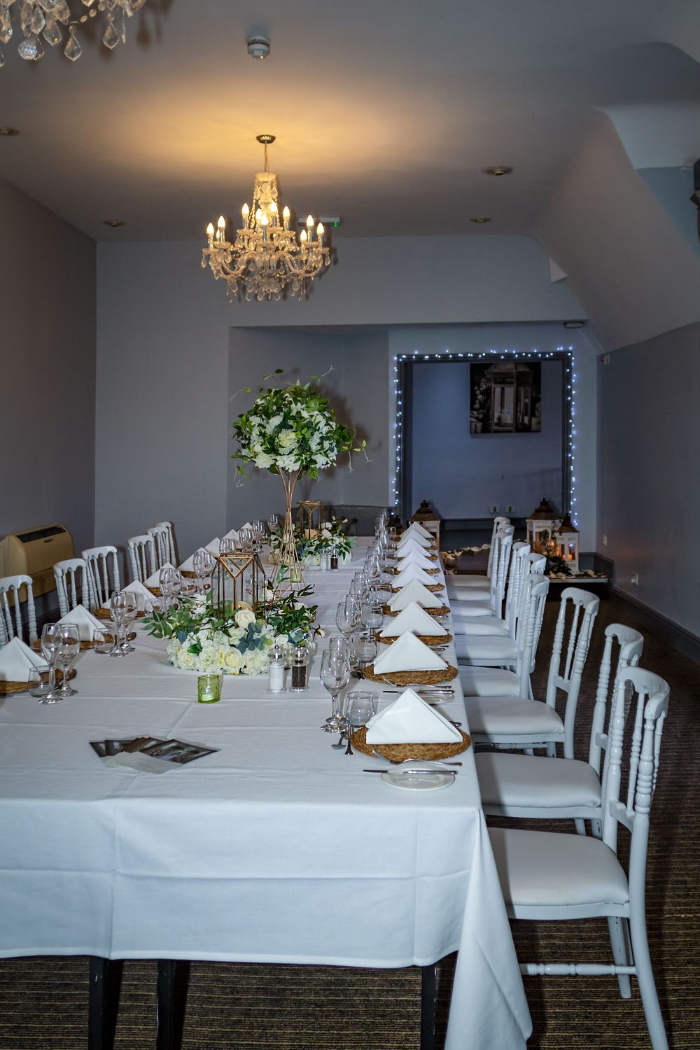 Elegant dining room setup with crystal chandelier and formal place settings.