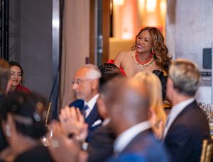 Audience members applauding during formal evening event.