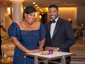 Elegantly dressed attendees sharing conversation at formal networking event.