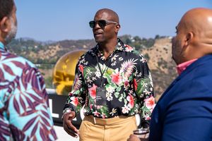A person in a floral shirt and khakis mingles at an outdoor social gathering.